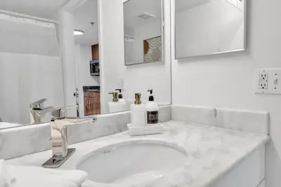 a white bathroom with a sink and a mirror at Marvelous Studio in Brickell Free Parking in Miami
