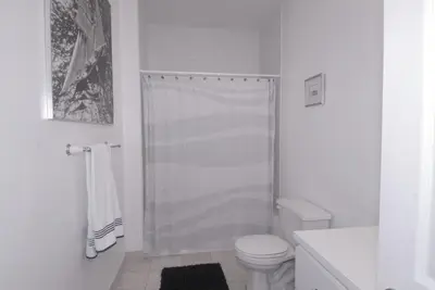 a white bathroom with a shower and a toilet at Luxury Ocean Front Condo on Millionaires Row in Miami Beach