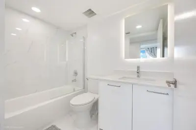 a white bathroom with a toilet and a sink at Lux 3BR City-View Retreat in Hollywood, 2nd Floor in Hollywood