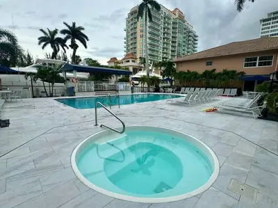 a large swimming pool with a tub in the middle of it at 1 Block from the Beach 2BR 2BA Newly Renovated in Fort Lauderdale