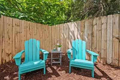 two blue chairs and a table in front of a fence at Daiquiri in Dania Beach