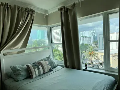 a bed in a room with a large window at Casablanca miami beach in Miami Beach