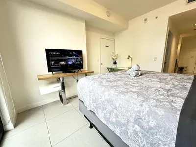 a bedroom with a bed and a flat screen tv at Doral Studio with Fabulous View in Miami