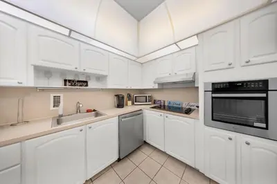 a white kitchen with white cabinets and appliances at Oceanfront Luxury Condo with Stunning Views and Resort Amenities in Hollywood