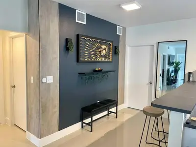 a living room with a black bench and a wall at Modern Home w Jacuzzi Near Wynwood-Design District-MIA Airport in Miami