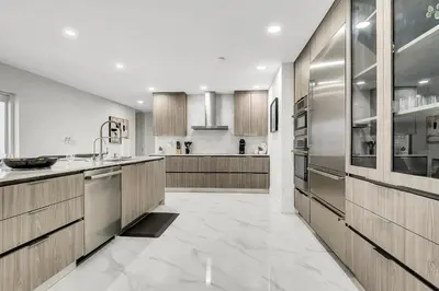 a large kitchen with wooden cabinets and stainless steel appliances at Villa Oasis with Heated Pool,Sauna, BBQ and Pool Table in Pinecrest
