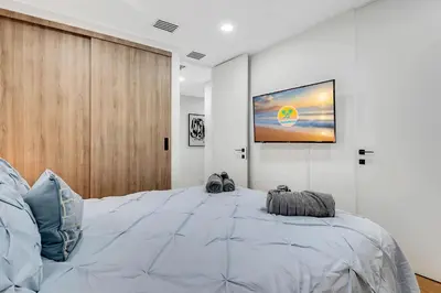 a bedroom with a large bed with a tv on the wall at Villa Oasis with Heated Pool,Sauna, BBQ and Pool Table in Pinecrest