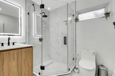 a bathroom with a shower with a toilet and a sink at Villa Oasis with Heated Pool,Sauna, BBQ and Pool Table in Pinecrest