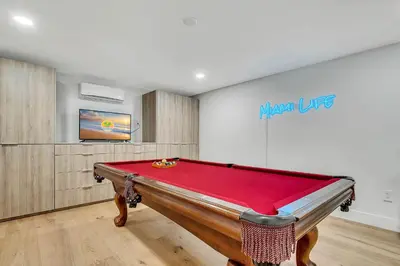 a room with a pool table in front of a wall at Villa Oasis with Heated Pool,Sauna, BBQ and Pool Table in Pinecrest