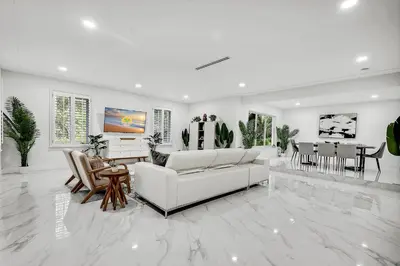 a white living room with a couch and a table at Villa Oasis with Heated Pool,Sauna, BBQ and Pool Table in Pinecrest