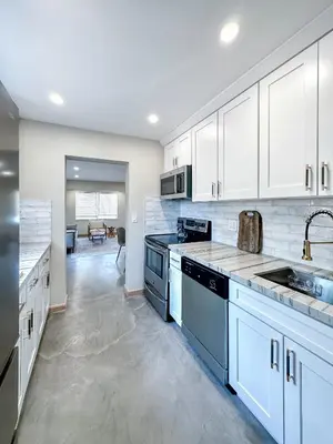 a kitchen with white cabinets and blue appliances at Imagine Residence in Hallandale Beach