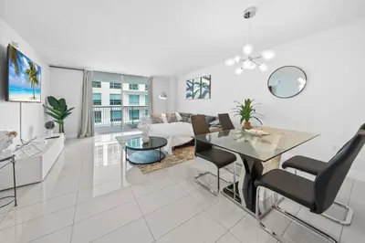 a white living room with a table and a couch at 36th-Floor Ocean View Brickell - Free Parking in Miami