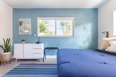 a bedroom with a bed and a blue wall at Beach Oasis King Bed & Near Hollywood beach in Hollywood