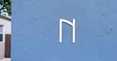 a white sign on the side of a blue wall at Peaceful Casita near Hollywood Beach & essentials in Hollywood