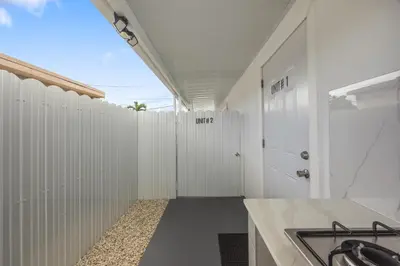 a kitchen with white walls and a white fence at Nice,Stylish King Bed Studio in Miami Gardens