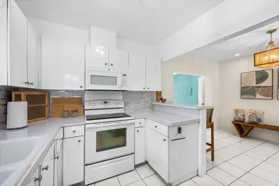 a kitchen with white cabinets and white appliances at Beach Home Estate I Pool & Ocean in Fort Lauderdale