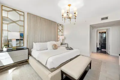 a bedroom with a large white bed and a chandelier at Oceanview Private Condo at The Setai -2604 in Miami Beach