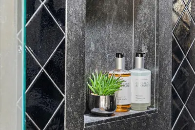 two bottles of essential oils and a plant on a shelf at Oceanview Private Condo at The Setai -2604 in Miami Beach