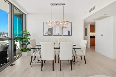 a dining room with a table and white chairs at Oceanview Private Condo at The Setai -2604 in Miami Beach