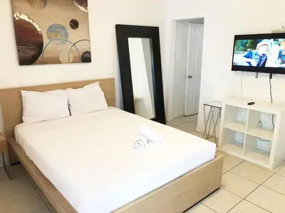 a bedroom with a bed and a tv in it at Krymwood Flats Wynwood in Miami