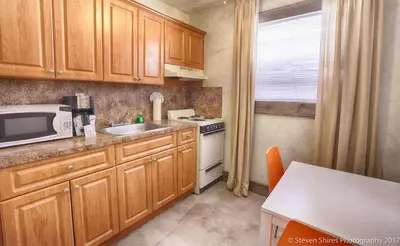 a kitchen with wooden cabinets and a sink and a microwave at Krymwood Flats Wynwood in Miami