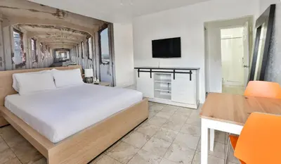 a bedroom with a bed and a desk and a television at Krymwood Flats Wynwood in Miami