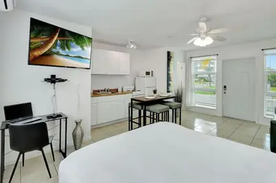 a bedroom with a bed and a kitchen with a table at Sunlit Studio Escape Hollywood Haven, sleeps 4 in Hollywood
