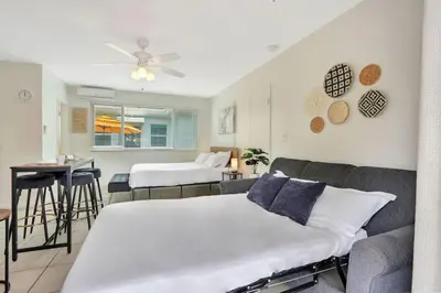 a bedroom with a bed and a couch and a table at Sunset Bliss Hollywood Seaside Studio Retreat in Hollywood