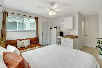 a bedroom with a large white bed and a kitchen at Seaside Serenity Hollywood Studio Escape in Hollywood