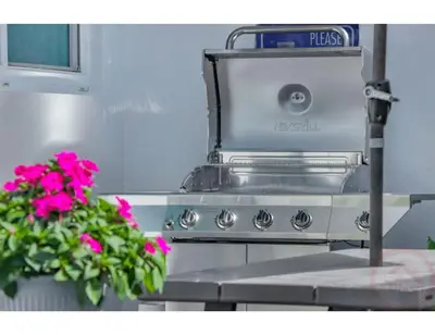 a stove with a pot of pink flowers in a kitchen at Seaside Serenity Hollywood Studio Escape in Hollywood