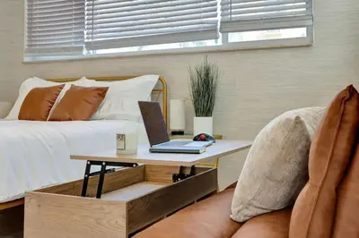 a bedroom with a bed and a laptop on a table at Seaside Serenity Hollywood Studio Escape in Hollywood