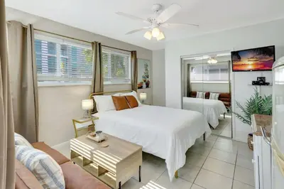 a bedroom with two beds and a living room at Sandscape Haven Hollywood Beach Studio w Parking in Hollywood
