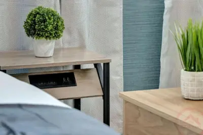 a table with a plant on it next to a bed at Studio Oasis near Hollywood Boardwalk in Hollywood