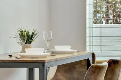 a dining room table with glasses and plates and chairs at Coastal Retreat ONLY 1 block from the beach in Hollywood
