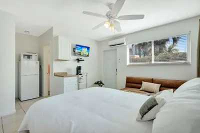 a bedroom with a white bed and a ceiling fan at Beachside Bliss Hollywood Studio in Hollywood