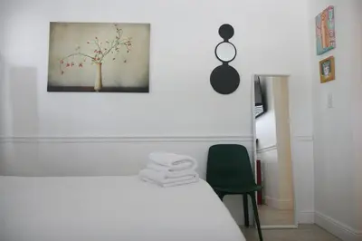 a bedroom with a white bed and a green chair at B11 Design District Studio Short drive 2 beach in Miami