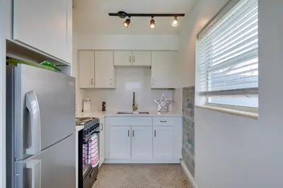 a kitchen with white cabinets and a refrigerator at 3 Mi to Beach Quaint Home with Patio in Hollywood in Hollywood