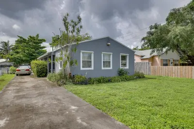 a blue house with a car parked in a yard at 3 Mi to Beach Quaint Home with Patio in Hollywood in Hollywood