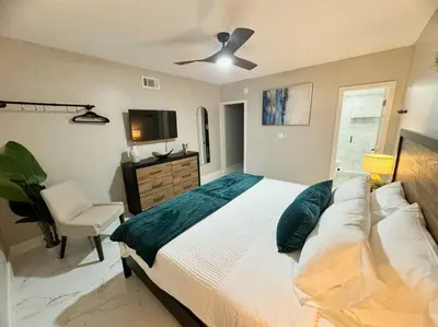 a bedroom with a bed and a tv and a chair at 3Bd 2Bath 1 Block from the beach! Newly renovated in Fort Lauderdale