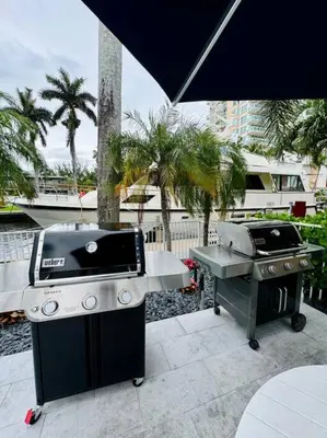 two bbqs and a grill under an umbrella at 3Bd 2Bath 1 Block from the beach! Newly renovated in Fort Lauderdale