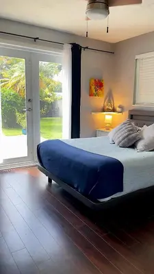 a bedroom with a large bed with a large window at Heated Pool Private Duplex House, BBQ, Parking, WiFi in Cutler Bay