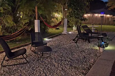 a backyard with two chairs and a hammock and a grill at Heated Pool Private Duplex House, BBQ, Parking, WiFi in Cutler Bay