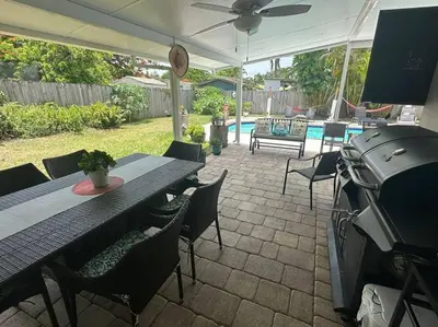 a patio with a table and chairs and a grill at Heated Pool Private Duplex House, BBQ, Parking, WiFi in Cutler Bay