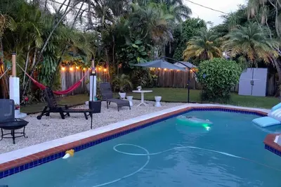 a swimming pool with a hammock in a backyard at Heated Pool Private Duplex House, BBQ, Parking, WiFi in Cutler Bay