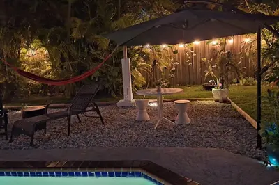 a hammock and an umbrella in a yard at night at Heated Pool Private Duplex House, BBQ, Parking, WiFi in Cutler Bay