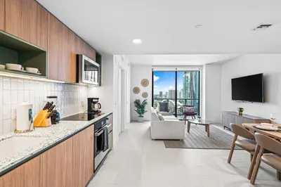a kitchen and living room with a view of the city at New Luxury 26th Floor Apartment in the heart of Miami in Miami
