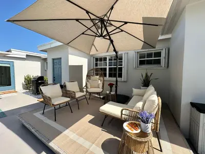a patio with furniture and a large umbrella at AQUAMARIA HOME - perfect stay for groups in Fort Lauderdale