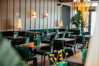 a dining room with tables and green chairs at 49th Floor Sleek Condo Cozy Pool, Gym and Spa Stay in Miami
