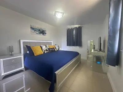 a bedroom with a bed with blue sheets and yellow pillows at Relaxing Studio Getaway w BBQ, Patio and Parking in Pembroke Pines