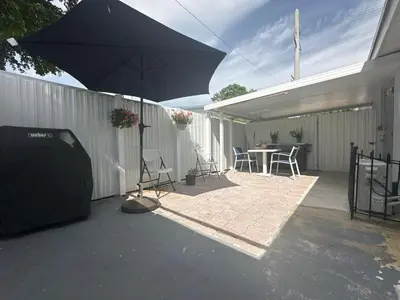 a patio with an umbrella and a table and chairs at Relaxing Studio Getaway w BBQ, Patio and Parking in Pembroke Pines